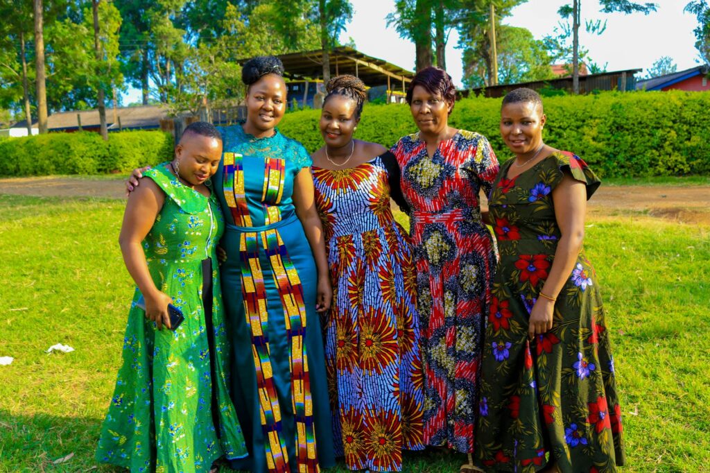 women in floral dresses stranding on grass field